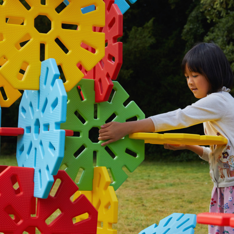Niños construyendo con juguetes grandes de Polydron